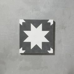 a black and white square with an arrow on the center is mounted to a wall