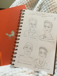 an open notebook with drawings of people on it