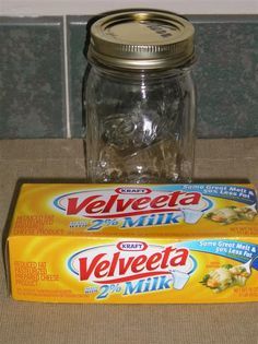 two boxes of velveeta sitting on top of a counter next to a glass jar