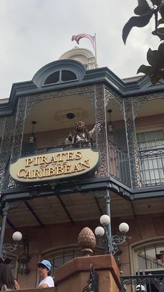 people are standing in front of a building with a sign that says pirates caribbean on it