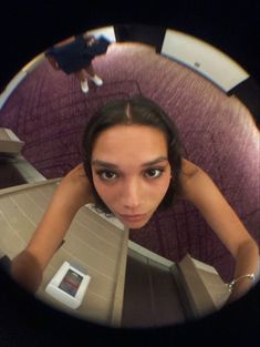 a woman looking at the camera through a fisheye lens