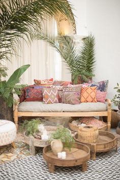 a living room filled with lots of furniture and plants