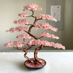 a pink bonsai tree sitting on top of a table