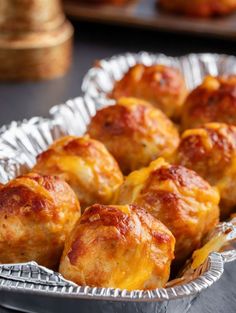 some food is sitting in a metal pan on a black table and it looks like they have been baked