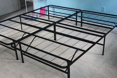 a metal bed frame sitting on top of a carpeted floor