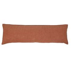 an orange pillow on a white background with a black stripe down the middle and a brown border around it