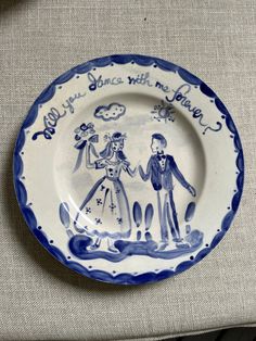 a blue and white plate with two people holding hands