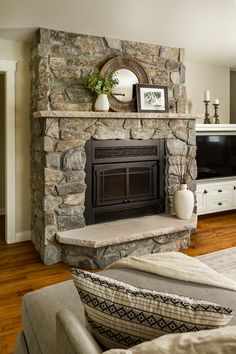 a living room with a stone fireplace and entertainment center