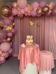 a table with a cake and balloons on it