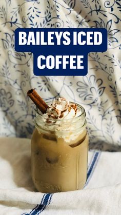 a glass jar filled with whipped cream and cinnamon on top of a blue and white blanket