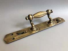 an antique brass door handle on a white surface