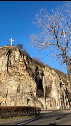 a cross on the top of a rock formation