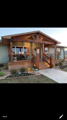 a small house that is in the middle of some grass and dirt with stairs leading up to it