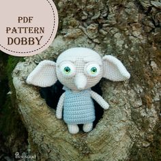 a crocheted stuffed animal sitting in the middle of a tree trunk with text overlay that reads, free pattern dobby