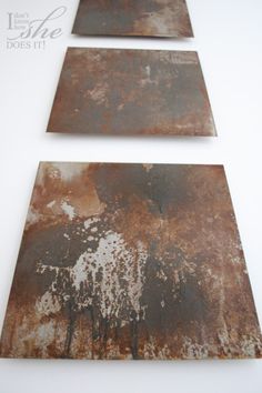 two pieces of rusted metal sitting on top of a white table next to each other