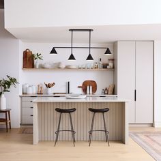 two stools are sitting at the kitchen island