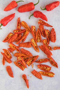 several red peppers on a white surface next to each other