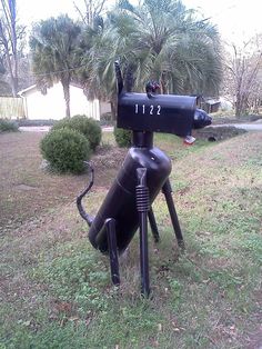 a black mailbox sitting on top of a grass covered field