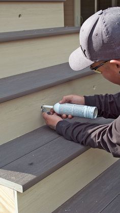 a man is painting the steps outside with paint rollers and a spray bottle in his hand