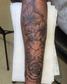 a person with a tattoo on their arm holding a clock