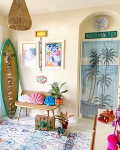 a living room filled with lots of furniture and art on the wall next to a surfboard