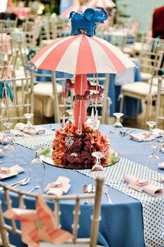 an umbrella is on top of a table with blue and white tables cloths in the background