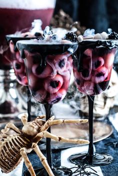 two glasses filled with ice cream and jelly in front of a skeleton on the table