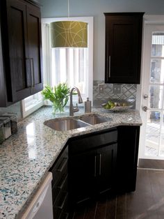 a kitchen with granite counter tops and dark wood cabinets, before and after remodeling