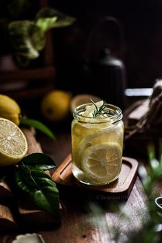 a glass jar filled with lemonade sitting on top of a wooden cutting board