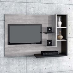 an entertainment center with a flat screen tv mounted on the wall and shelves below it