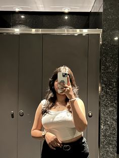 a woman taking a selfie in front of a mirror