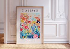 a framed poster on the floor with flowers in front of it and an inscription matissee