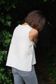 a woman in jeans and a white top is looking at something off to the side