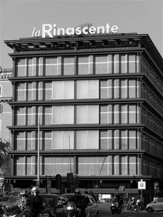 two police officers on motorcycles in front of a building with the word la rinascente written above it