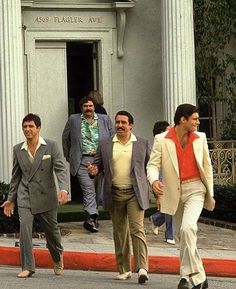 several men walking down the street in front of a building