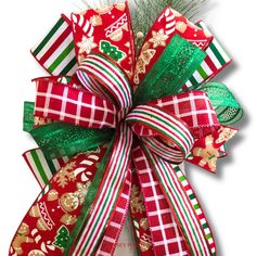 a red and green christmas bow with gold, white and green decorations on it's side