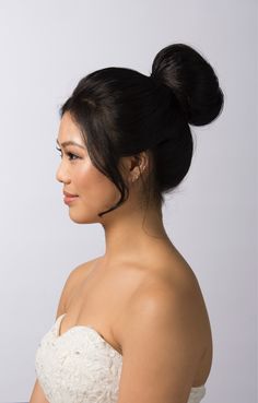 a woman in a strapless dress with a high bun