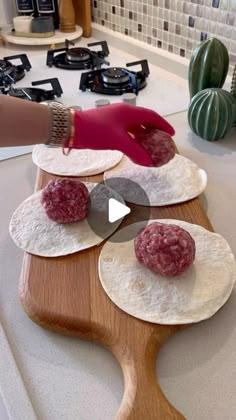 a person in red gloves is making food on a cutting board with tortillas