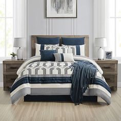 a bed in a bedroom with blue and white comforter on top of the bed