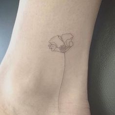 a single flower tattoo on the side of a woman's foot, which is drawn in black ink