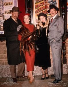 three people standing next to each other in front of posters