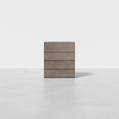 an empty wooden dresser sitting on top of a white floor in front of a wall