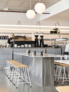 two women are sitting at the counter in a coffee shop with stools and tables