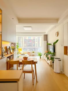 a living room filled with furniture next to a window covered in plants and potted plants