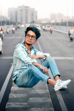 a man sitting on the side of a road