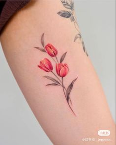 a woman's thigh with red flowers on her left side and the word love written in chinese