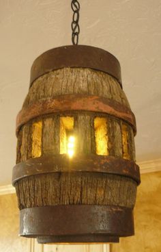 a wooden light fixture hanging from a ceiling in a room with a chain on it