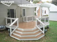 a deck with steps and trelliss in front of a house