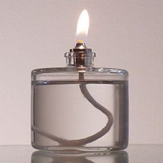 a lighter is lit on a table with a white wall in the backround