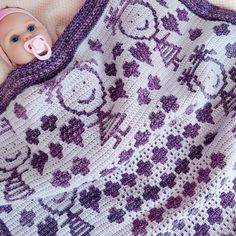 a crocheted blanket with a baby doll on it